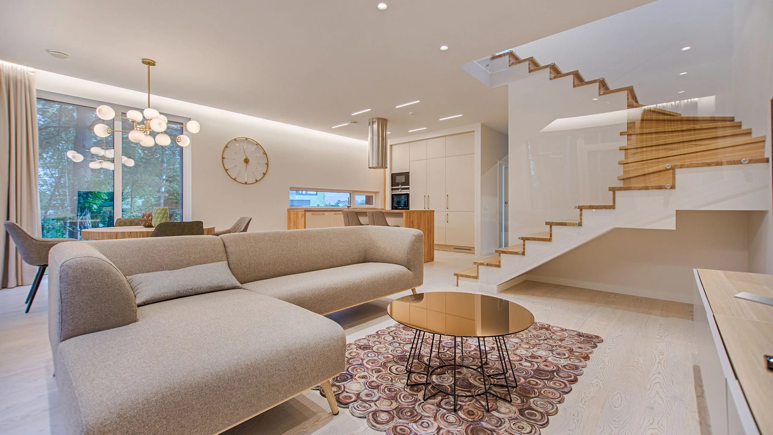 A contemporary living room with a wooden staircase